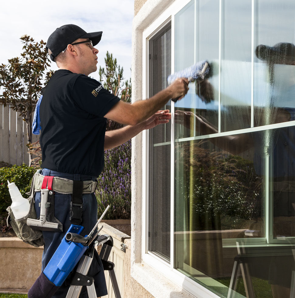 Man cleaning window of a home.